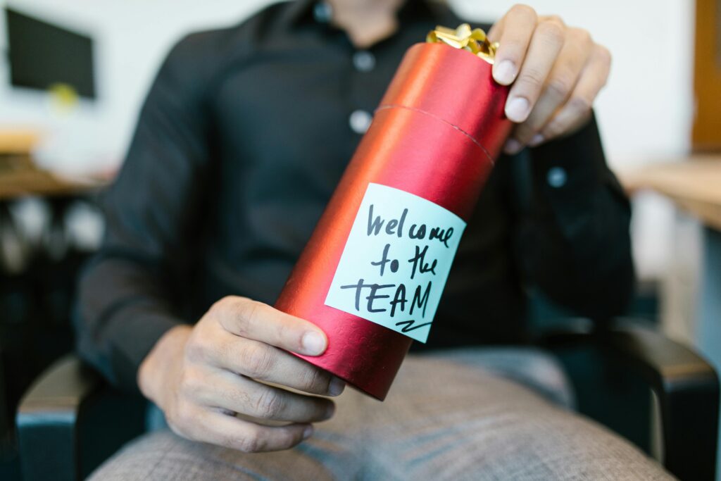 Person holding a water bottle with a sticky note that says "Welcome to the team"